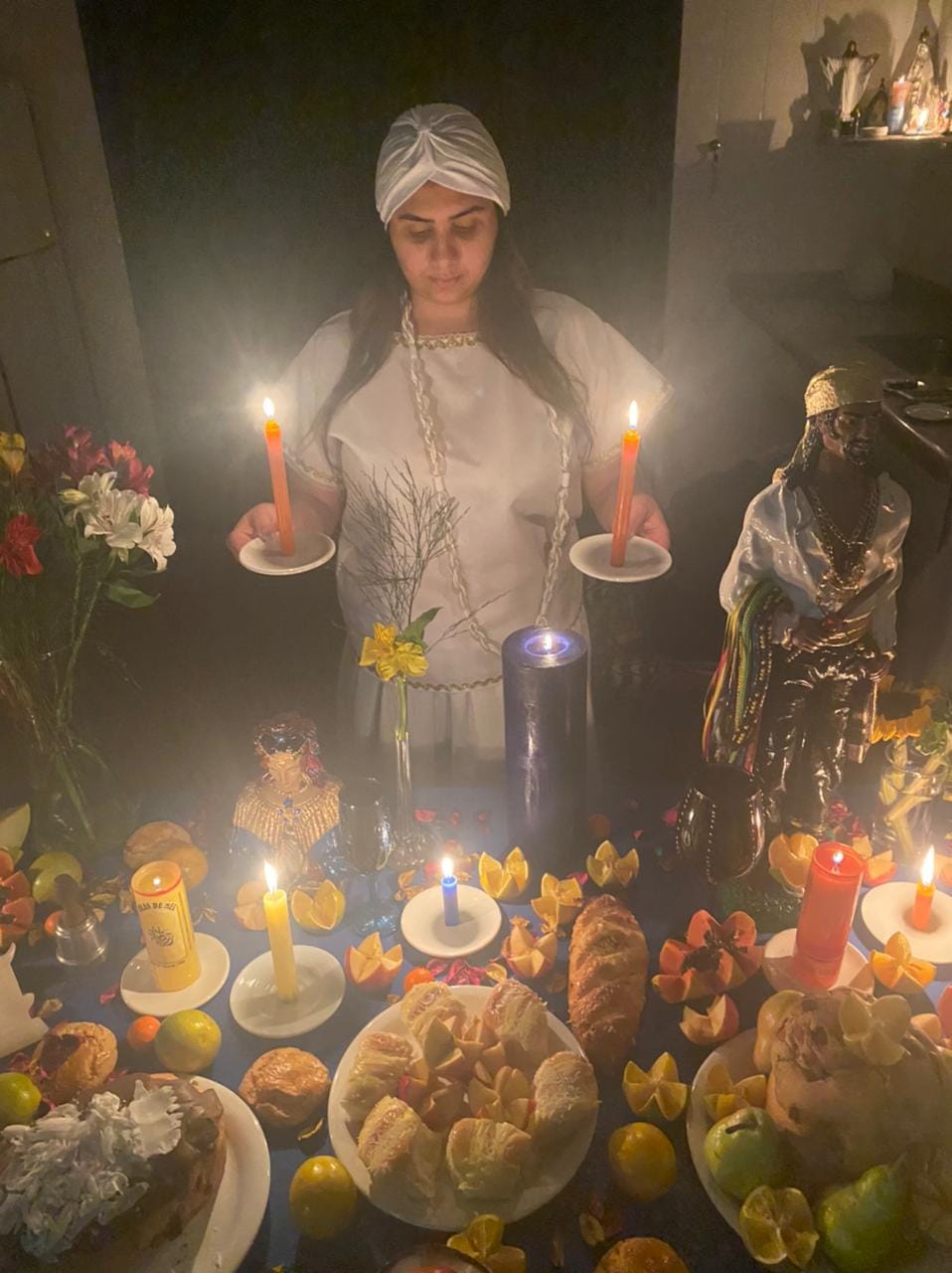 Vidente Dyana firmando velas em altar de amor com oferendas