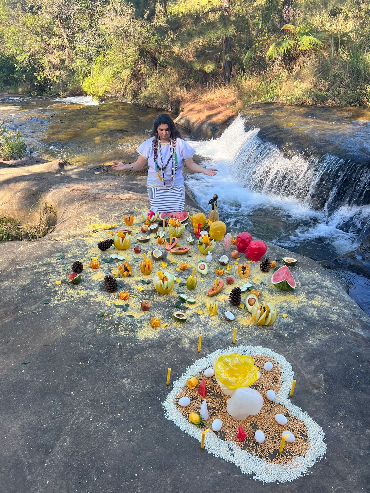 Vidente Dyana realizando trabalho de amor na cachoeira, com oferendas e velas